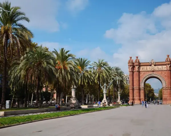 Łuk Triumfalny w Barcelonie, z rzędem palm i błękitnym niebem, to ikoniczne miejsce, które podkreśla wspaniałe barcelona położenie.