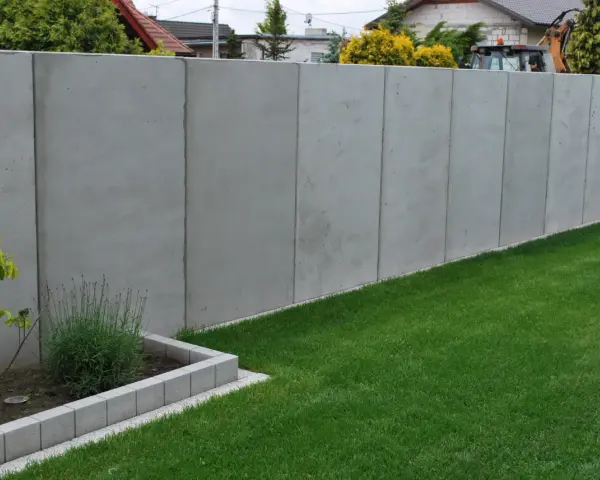 Betonowy mur wysoki na 2,2m. Unikaj najgorszych błędów przy zgłaszaniu budowy ogrodzenia powyżej 2,2 metra po nowym prawie.