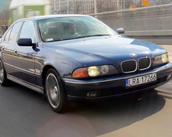 Niebieskie BMW serii 5 (E39) z silnikiem m52b20 jedzie po moście.
