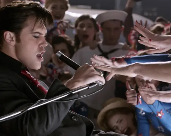 Elvis Presley, der Film: Ein junger Elvis singt mit Leidenschaft ins Mikrofon, umringt von jubelnden Fans.