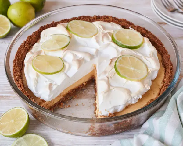 Ein köstlicher Key Lime Pie mit Baiserhaube und Limettenscheiben, bereit zum Genießen.