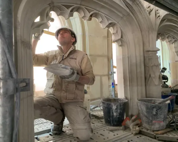 Un maçon restaure la voûte de la cathédrale de Nantes, un chantier qui suit l'incendie.