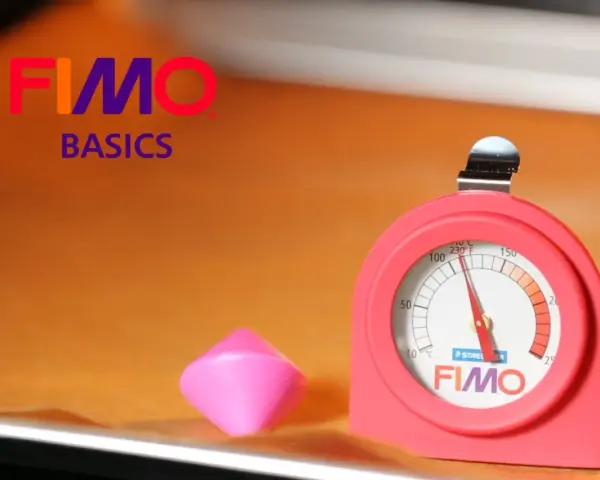 Termometro per forno per fimo, accanto a un pezzo di pasta modellabile rosa.