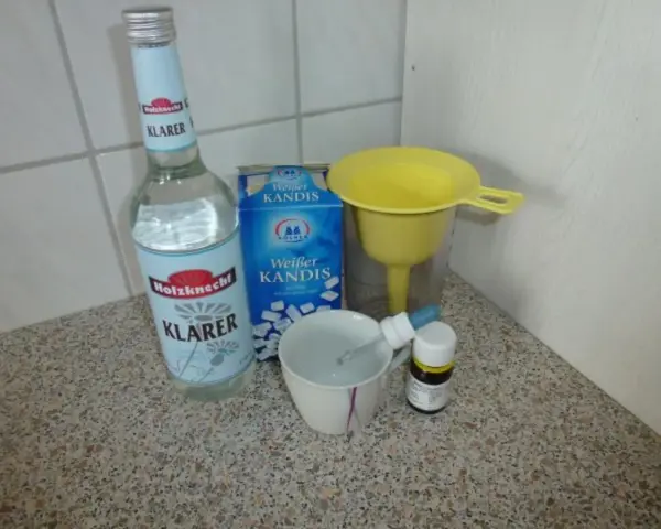 Zutaten für Ouzo selber machen: Klarer Schnaps, Kandiszucker, ein Trichter und eine Pipette.