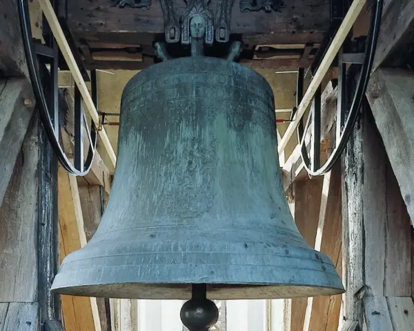Große, grüne Kirchenglocke im Glockenturm, bereit zum Läuten an Ostern.