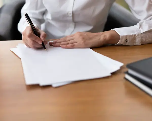 Ręka pisze piórem na białej kartce. Czy to umowa cywilnoprawna?