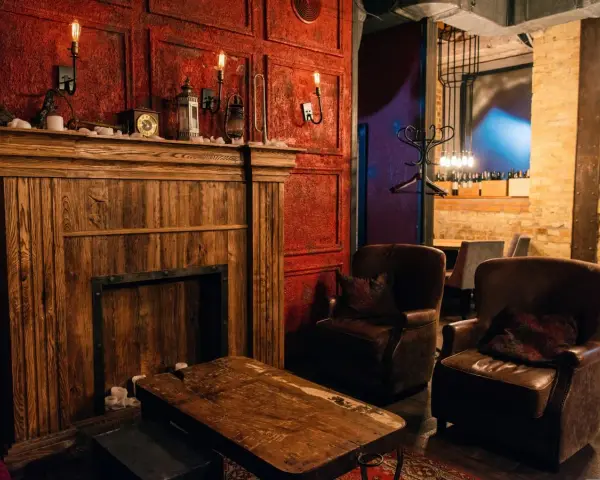 Drewniany kominek, skórzane fotele i lampy tworzą atmosferę **steampunk**.