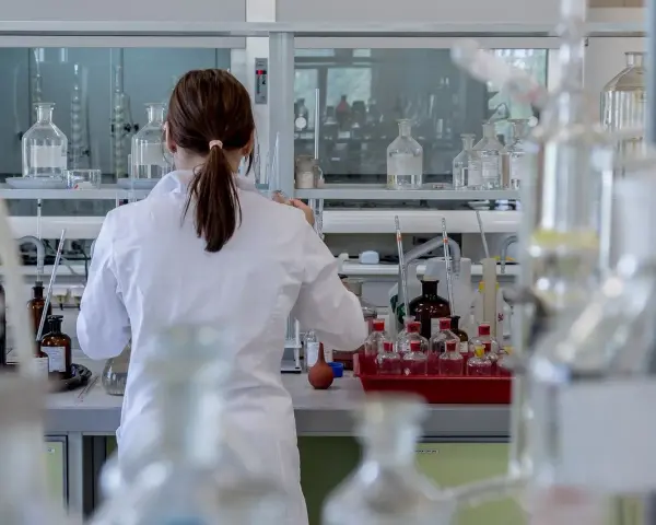 Naukowczyni w białym fartuchu pracuje w laboratorium chemicznym, przygotowując eksperyment. To kluczowy etap, jak otworzyć laboratorium chemiczne.