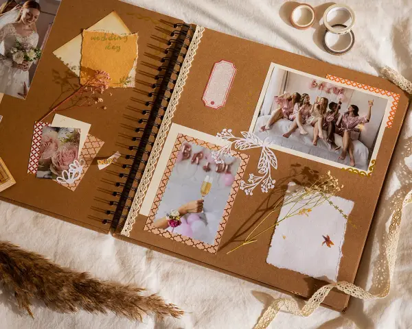 Otwarta księga wspomnień, gdzie co to jest scrapbooking widać na zdjęciach z wesela, ozdobiona wstążkami i suszonymi kwiatami.