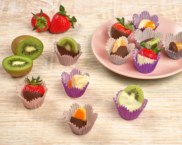 Fruktbitar doppade i choklad och vit choklad, serverade i färgglada cupcake formar. Jordgubbar, kiwi och apelsin.