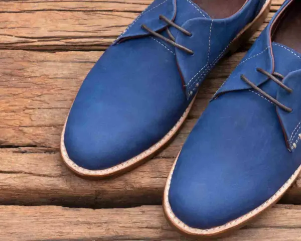Un paio di eleganti scarpe blu con lacci marroni, perfette per completare un abito blu.