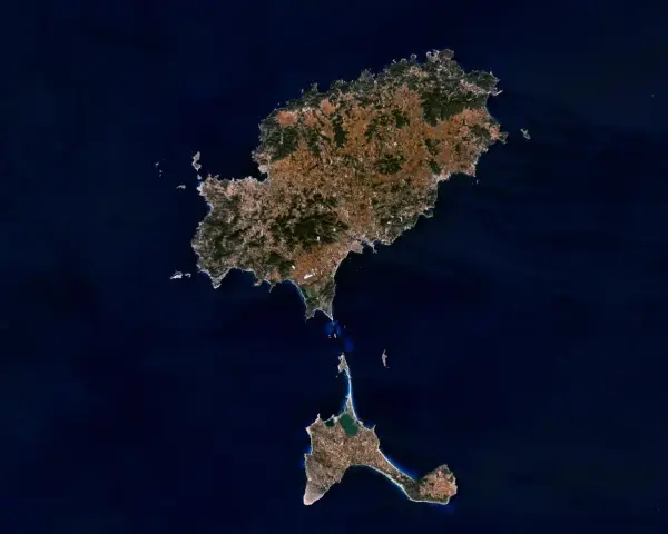 Widok z kosmosu na wyspy Ibiza i Formentera, gdzie jest Ibiza. Widać zielone wzgórza i zabudowania.