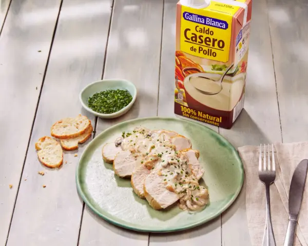 Lonchas de solomillo de pavo con salsa cremosa de champiñones, acompañadas de pan tostado y cebollino picado.