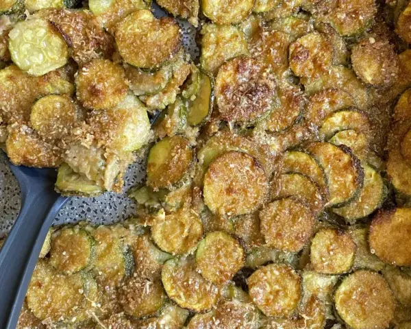 Fette di zucchine al forno semplici, dorate e croccanti, con una spolverata di parmigiano. Un contorno gustoso e facile da preparare.