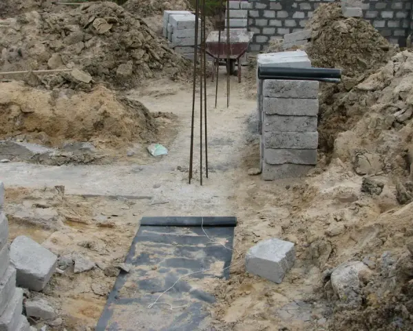 Budowa domu. Kopanie pod fundamenty, zbrojenie i pierwsze warstwy bloczków betonowych.