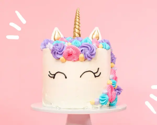 Magisk enhörningstårta med horn och öron, dekorerad med färgglad frosting. Ett perfekt unicorn tårta recept för kalaset!