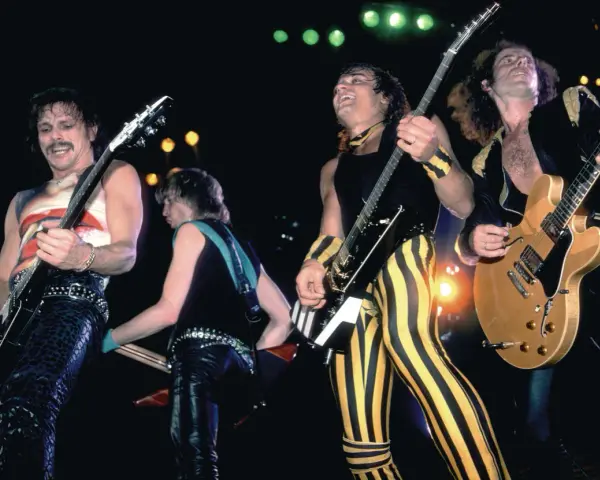 Le groupe Scorpion en pleine performance, des guitaristes aux looks audacieux, sur scène.