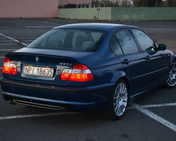 Niebieskie BMW E46 330d na parkingu. Wiele osób chwali ten model za osiągi i komfort.