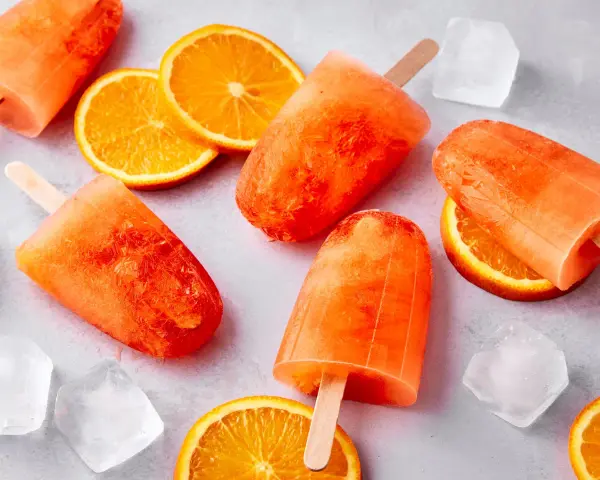 Erfrischendes Aperol Eis mit Orangenscheiben und Eiswürfeln. Perfekt für heiße Sommertage.