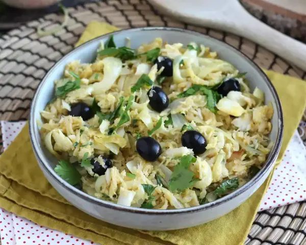 Delicioso bacalao a bras, desmenuzado con patatas finas, huevo y aceitunas negras, adornado con perejil fresco.