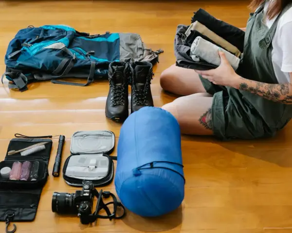 Plecak, buty trekkingowe, śpiwór, kosmetyczka, latarka, aparat i ubrania – to wszystko, co wziąć pod namiot na wyprawę.