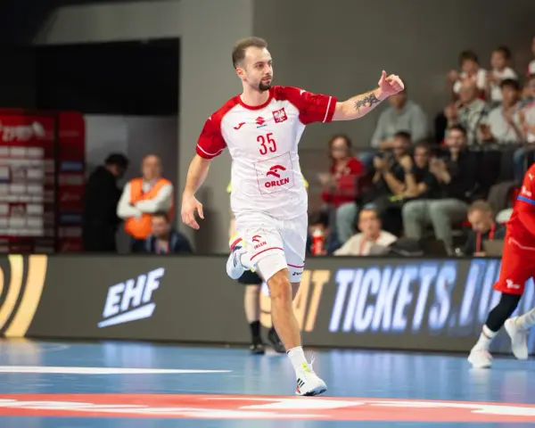 Paweł Paterek w akcji, z numerem 35 na koszulce, biegnie po boisku.