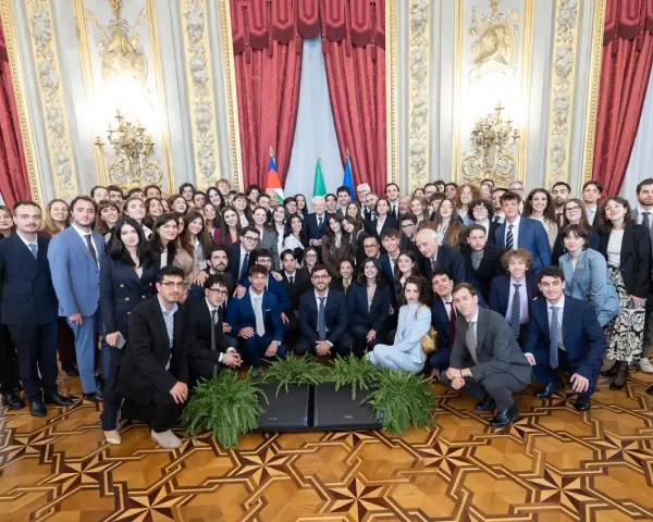 Un folto gruppo di giovani studenti posa per una foto di gruppo, forse dopo un evento alla scuola di giornalismo Roma.