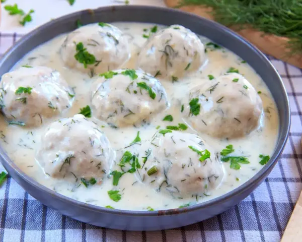 Pyszne mielone w kremowym sosie koperkowym, posypane świeżym koperkiem i pietruszką. Idealne danie obiadowe.