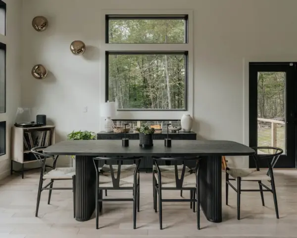 Elegante mesa negra y sillas de diseño para una perfecta decoracion comedores modernos. Ventanales con vistas al bosque.