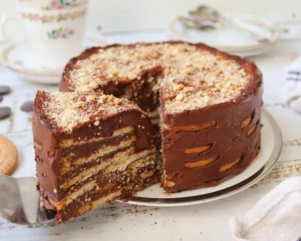 Deliciosa marquesa de chocolate, un postre casero con capas de galletas y crema de cacao, espolvoreada con frutos secos.