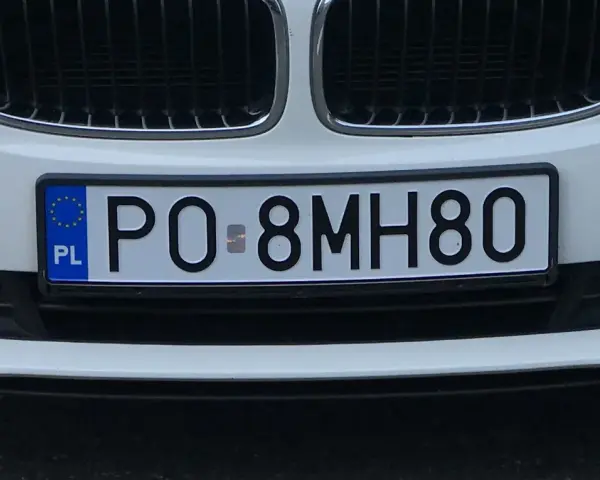 Białe BMW z tablicą rejestracyjną PO 8MH80.