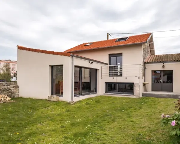 Maison avec extension moderne, jardin verdoyant. Le prix d'une extension maison 20m2 peut varier, mais ce type d'agrandissement offre un espace de vie supplémentaire.