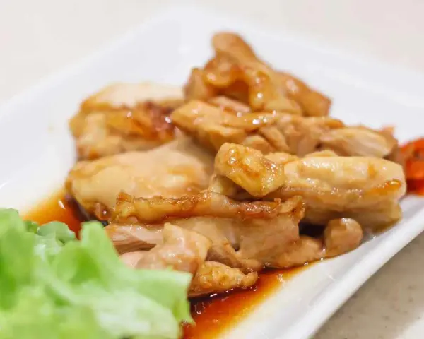 Straccetti di pollo succulenti in salsa teriyaki, serviti con lattuga fresca e carote sottaceto.