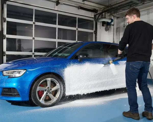 Man skummar en blå bil med Autoglym Polar Blast.