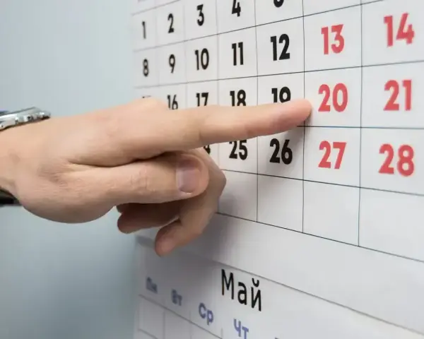Palec wskazuje datę 20 na kalendarzu. Czas na podjęcie decyzji o okresie wypowiedzenia umowy o pracę.