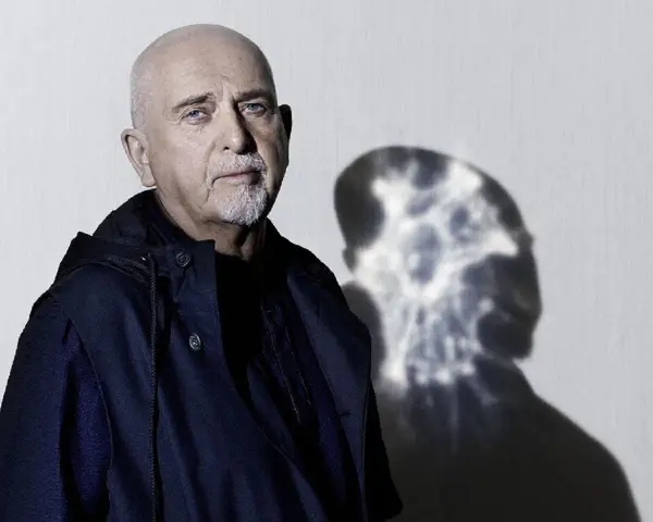 Peter Gabriel z charakterystycznym cieniem na ścianie, zapowiadający nową płytę.