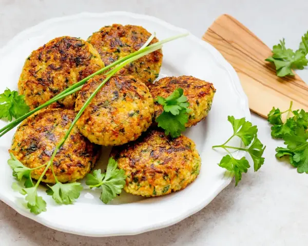 Goldbraune Hirse-Patties, garniert mit frischen Kräutern, sind ein köstliches Beispiel für Hirse Gerichte.