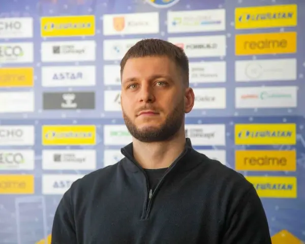 Aleks Vlah, z charakterystyczną brodą i krótką fryzurą, pozuje na tle ścianki z logotypami sponsorów, m.in. "ECHO" i "realme".
