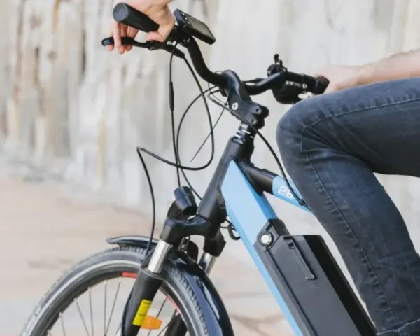 Osoba na rowerze elektrycznym, który jest pojazdem mechanicznym, jedzie po mieście.