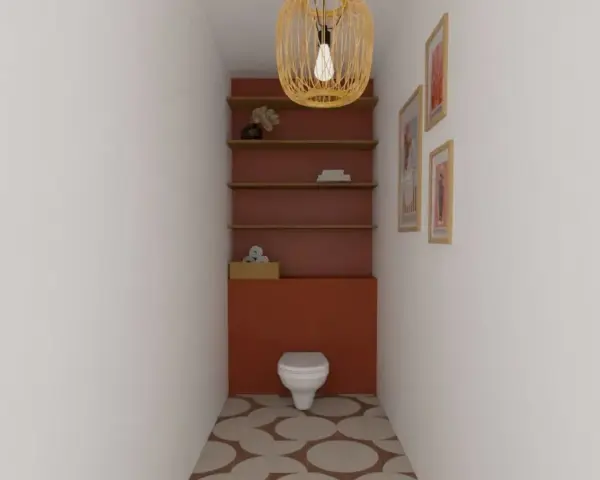 Un WC blanc est niché dans un alcôve aux murs rouge brique. Des étagères en bois flottent au-dessus, ornées d'objets décoratifs. Le sol est carrelé de cercles dans des tons terreux.