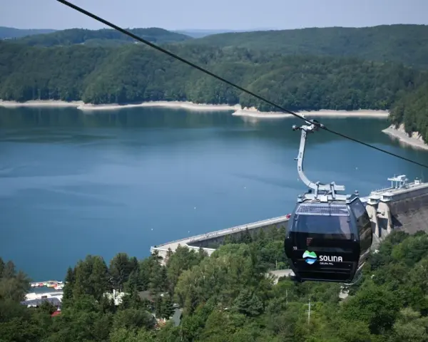Kolejka linowa nad Soliną, idealna na podróż pociągiem w Bieszczady. Widok na zaporę i jezioro.
