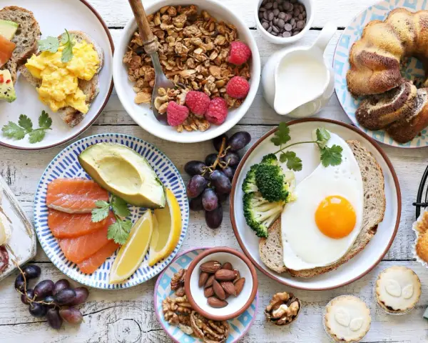Leckeres Fingerfood für den Osterbrunch: Rührei, Lachs, Avocado, Kuchen, Muffins und Nüsse.
