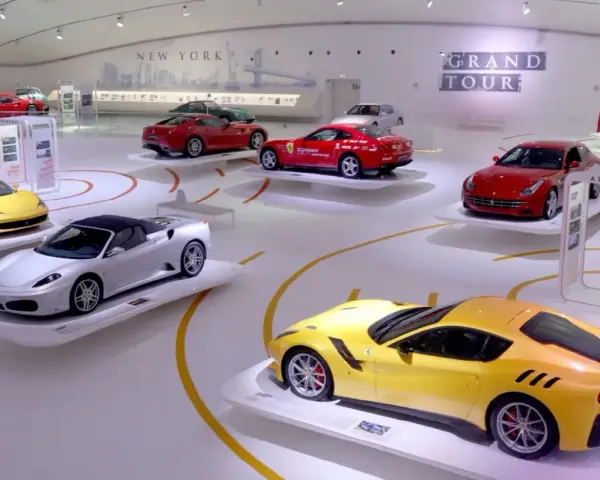 W muzeum Ferrari w Maranello lub w Modenie, na wystawie "Grand Tour", prezentowane są lśniące modele, w tym żółty i srebrny kabriolet.