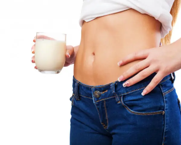Donna con bicchiere di latte, un aiuto per sapere cosa bere la sera per andare di corpo.