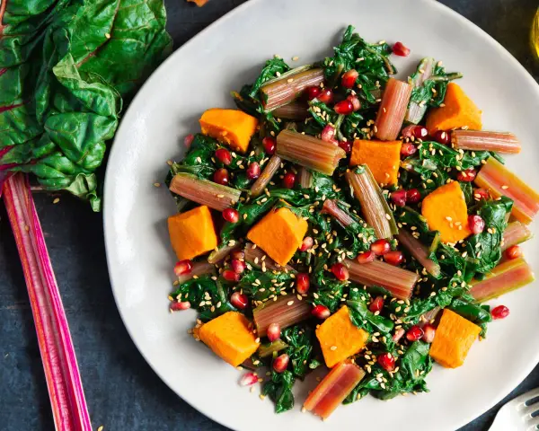 Ensalada vibrante con acelgas, calabaza, granada y semillas de sésamo. Una de las muchas recetas con acelgas que te encantarán.