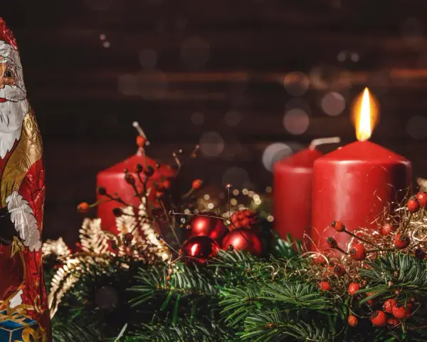 Schokoladen-Nikolaus und Adventskranz mit brennender Kerze. Der zweite Adventssonntag ist da!