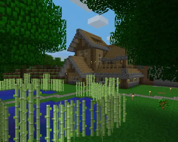 Drewniany dom z kamiennymi elementami, otoczony bambusami i wodą. W Minecraft można budować takie cuda i tworzyć własne światy.