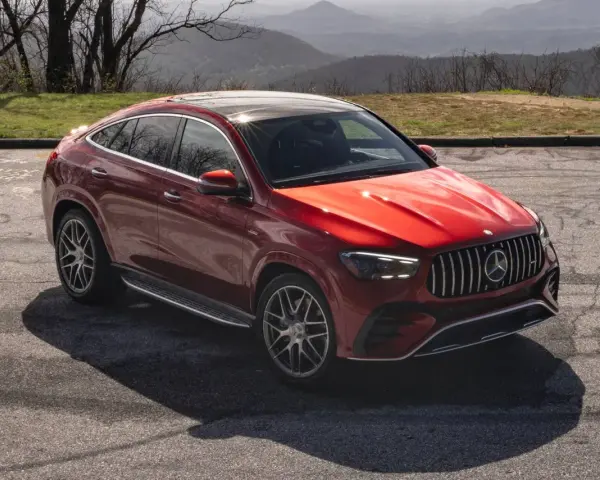 Czerwony Mercedes SUV, jeden z najnowszych mercedes suv modele, zaparkowany na tle górskiego krajobrazu.