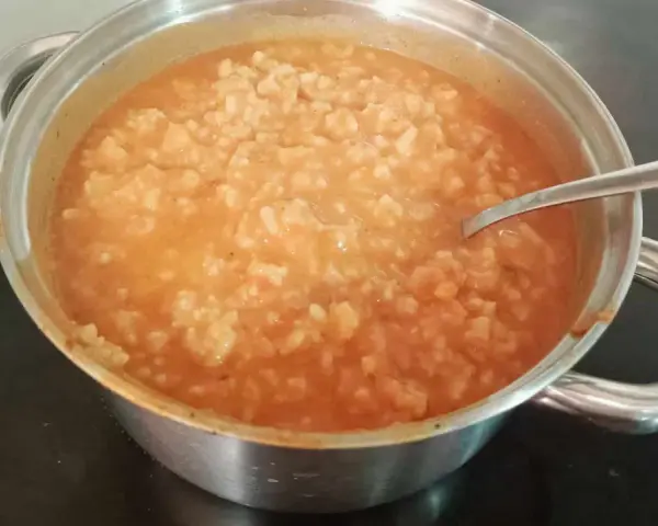 Gęsta zupa pomidorowa z ryżem w garnku, gotowa do podania. Idealny przepis na szybki obiad.