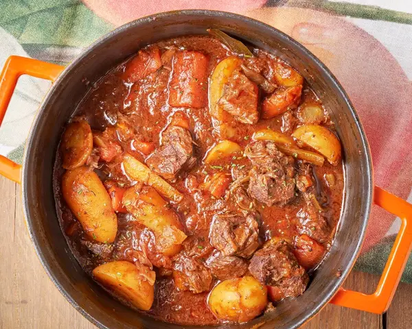Spezzatino con patate ricetta della nonna: carne tenera e patate succulente in un ricco sugo. Un classico confortante.